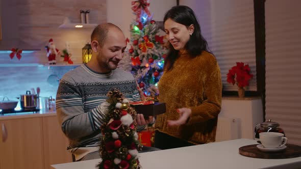 Woman Giving Gift Box to Man Celebrating Christmas Eve