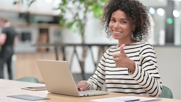 Positive Young African Woman with Laptop Doing Thumbs Up