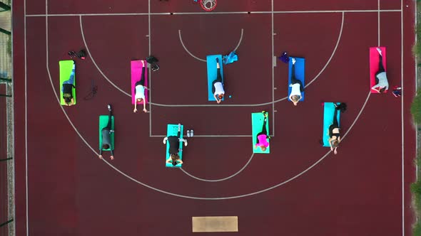 Group of Young People Doing Workout on the Red Sportground