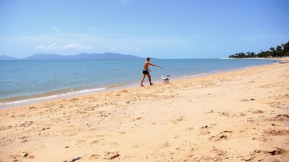 Man and Cute Dog Playing on the Beach