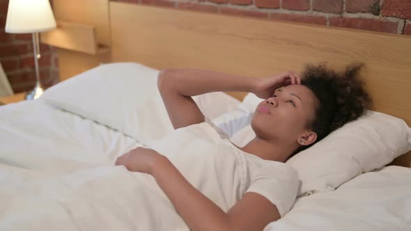Young African Woman Awake in Bed Thinking