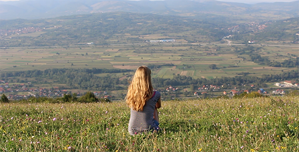 Girl Sitting on Top of the Hill Looking Far Away