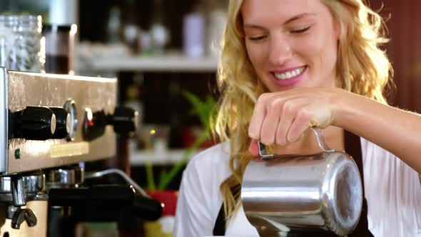 Smiling waitress making cup of coffee