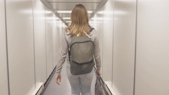 Aircraft Boarding. Female Going in to Gate Tunnel Passage Corridor at Airport