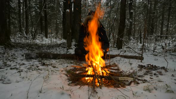 Person in Warm Jacket Silhouette Sits Near Burning Bonfire