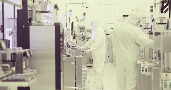 Workers in clean suits in a Semiconductor manufacturing facility