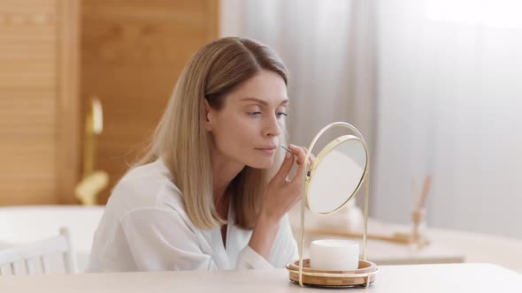 Pretty Middle Aged Lady Removing Moustache Above Upper Lips with Tweezers Looking at Mirror at