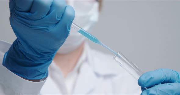 Technician Carefully Drips the Solution From the Pipette Into Glass Tubes.