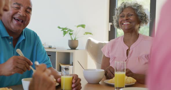 Happy senior diverse people having breakfast at retirement home