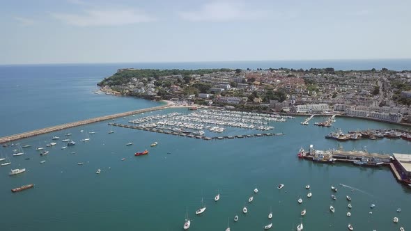 Aerial view of harbour town in southwest England. Flying over harbour in Brixham. Boats are docked.