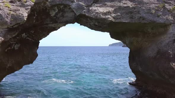 Flight over the Sea Surface through a Stone Arch