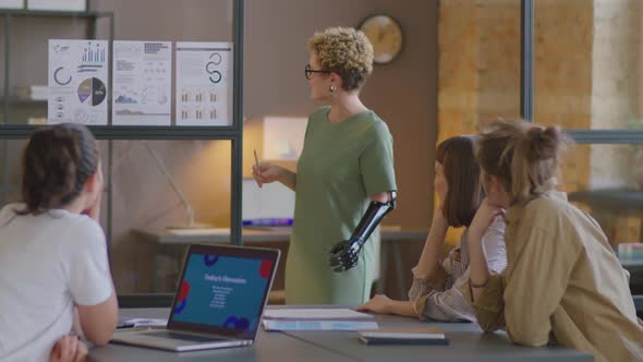 Businesswoman with Prosthetic Arm Giving Presentation in Office