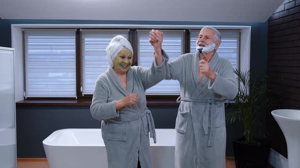 Senior Couple Man and Woman in Bathrobe Are Dancing in Bathroom Having Fun Enjoying Leisure Time