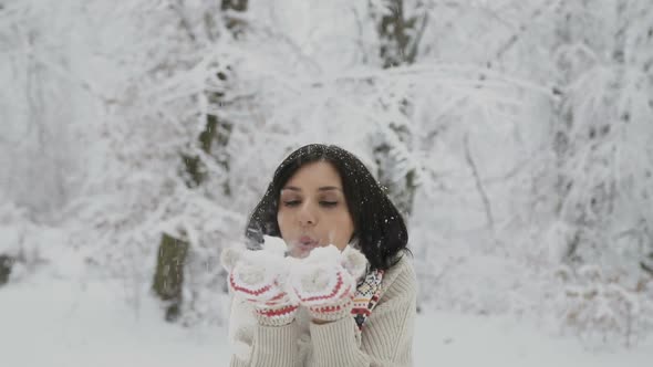 Young Woman Blows Snow Out of Her Knitted Mittens Girl Having Fun in Winter Park