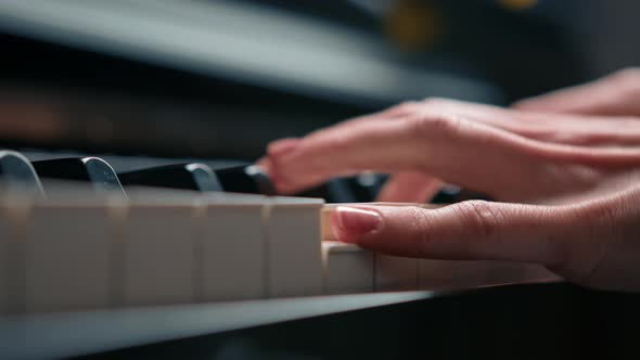 Selective focus to piano key and fingers to play the piano. There are musical instrument