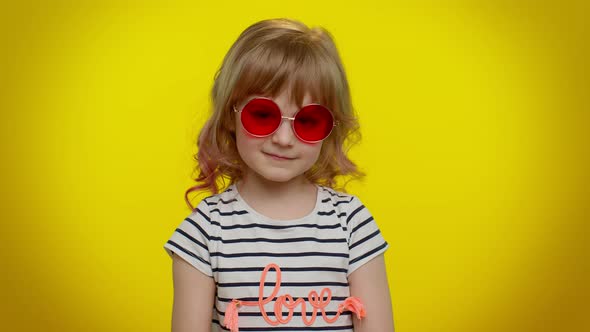 Happy Playful Kid Girl in Sunglasses Blinking Eye Looking at Camera with Smile Winking Flirting