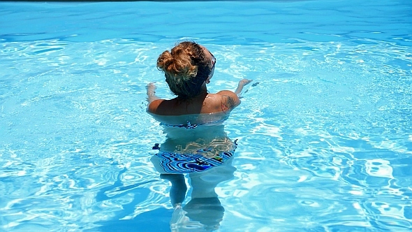 Woman Relaxing in Blue Swimming Pool