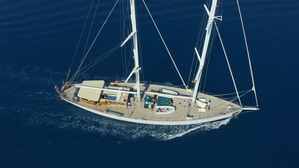 Aerial Top View of Sailing Boat with Water Splash on Blue Sea