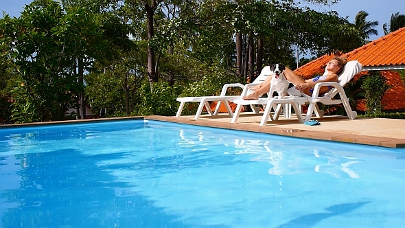 Woman with a Dog Relaxing near Pool