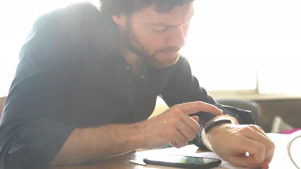 Man using smartwatch and smartphone at the same time