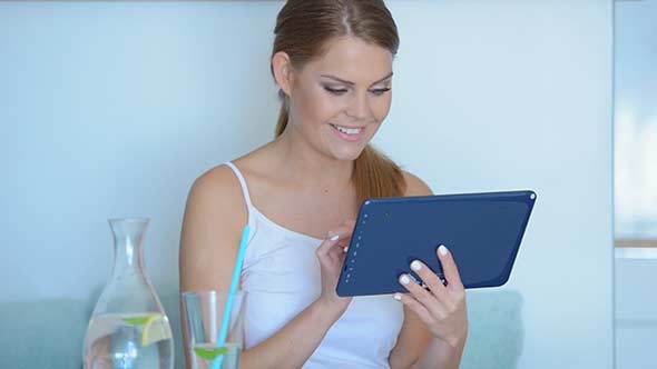 Young Woman Surfing The Internet On A Tablet