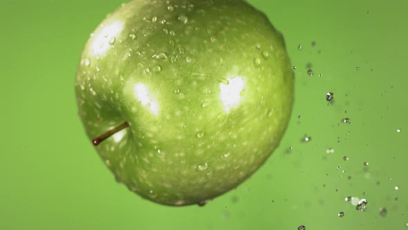 Flying of Green Apple in Green Background in Slow Motion