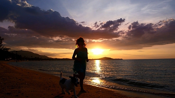Woman Running with a Dog at Sunset