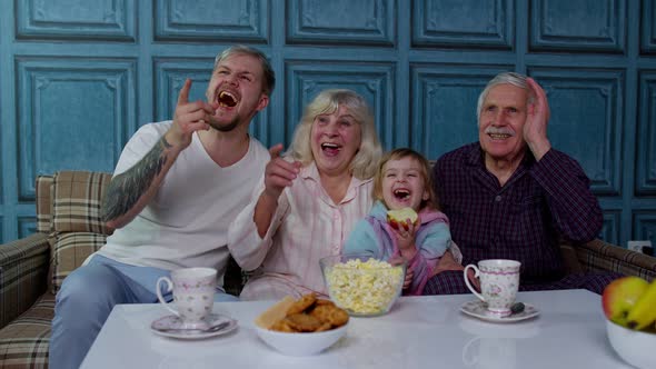 Multigenerational Happy Family Laughing Watching Cartoons Television Movies Eating Popcorn at Home
