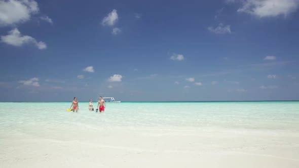 People Walking From Boat to Island