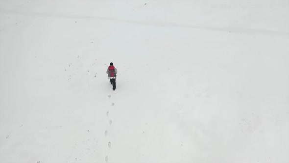 Aerial Top View: Human Walk By Snowy Desert.