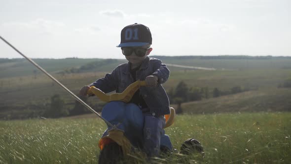 Toddler Kid in Funny Glasses Biking. Helping To Ride a Bike. Learning To Ride a Bike Concept.