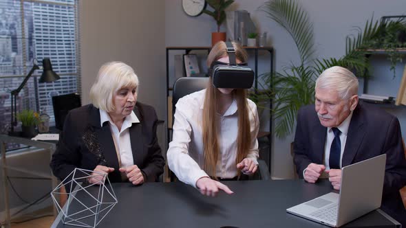 Woman Wearing Virtual Reality Glasses Tries 3D App for VR Helmet While Colleagues Supporting Her