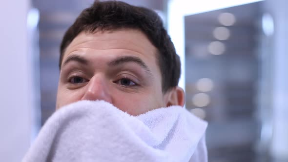 Handsome Man Look in Mirror in Bathroom Wipe Rub Face with Towel After Shower