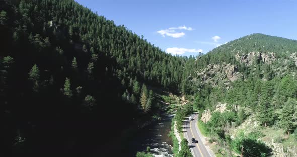 Mountains and a road in a drone pan framed by two tripod shots. 4k 60fps.  Rocky Mountain Colorado n
