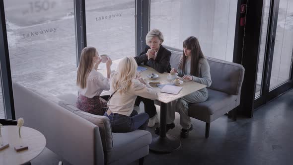 The Friends Met in a Cafe and are Glad That They Have Gathered