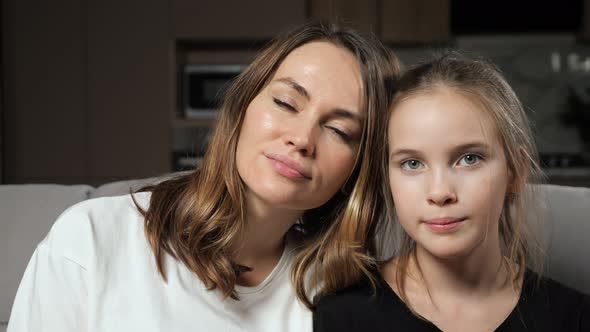 Mother and Daughter Smile Widely Looking in Camera at Home
