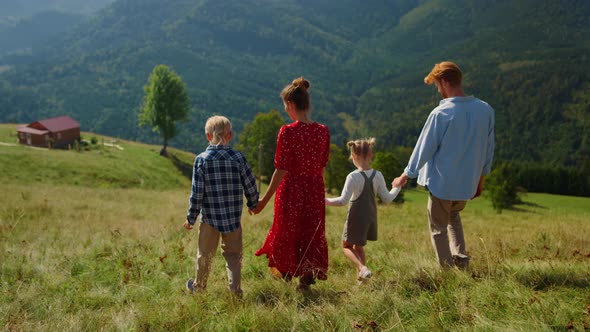 Back View Walking Family Going Down Green Hill