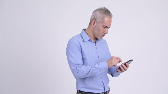 Happy Persian Businessman Using Phone and Looking Surprised