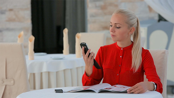 Woman Reading a Magazine and Talking on Cellphone