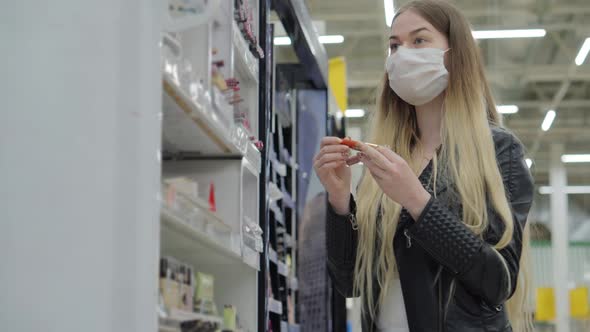 Young Female in Medical Mask Buying Lip Gloss in Supermarket