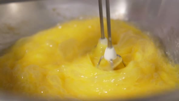 the Mixer Mixes the Egg Yolks in a Metal Shiny Bowl