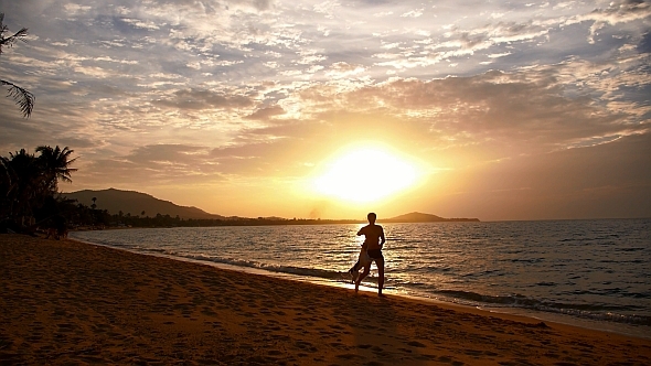 Man Playing with Dog at Sunset