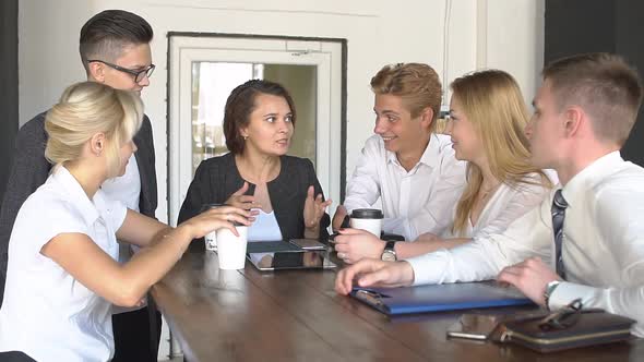 Happy Creative Team Drinking Coffee at Break and Having Discussion in Office Slow Motion