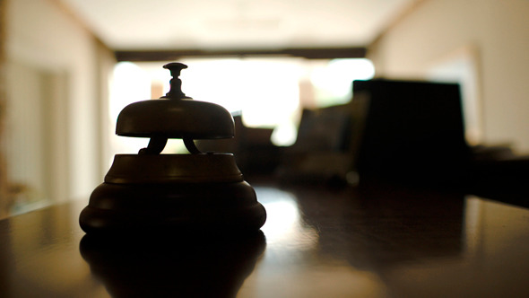 Woman Ringing Reception Bell In Hotel