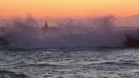 Slow motion view of sailboat on the horizon at sunset