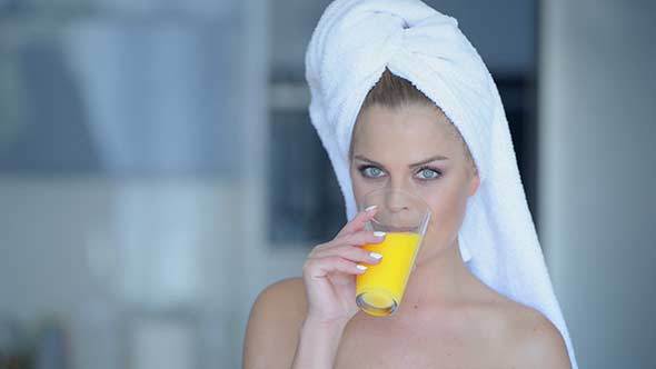 Woman in Towel Drinking Juice