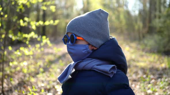 Boy Walks in a Mask Protected From the Virus and Colorful Round Glasses