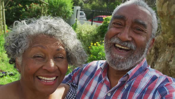 Animation of african american senior couple smiling at camera in garden