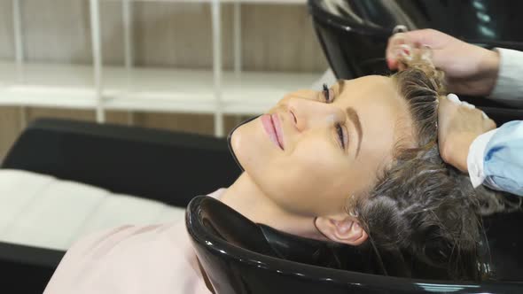 Cropped Shot of a Beautiful Woman Getting Her Hair Washed at the Hairdresser Salon