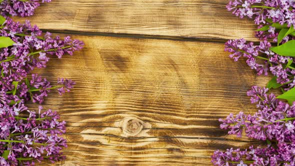 Bouquet of Lilac Flowers Lie on an Old Burnt Wooden Background